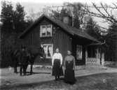 Bostadshus, familjegrupp  tre personer  och en häst framför huset.
Henning och Teckla Undén med dottern Alva.