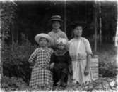 Familjegrupp fyra personer.
Erik Theon Olssons hustru Emma Lydia, med barnen Linnéa, Sven Erik och Thea Elfrida.