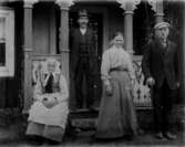 Bostadshus, fyra personer framför huset.
Stående på verandan Herman Andersson, nedanför L.J. Juhlin med fru Augusta.
Sittande Juhlins mor.