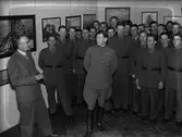 Intendent Nils Ålenius visar Olof Thunmans konstutställning för en grupp militärer, Upplands nation, Uppsala 1942