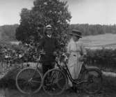 Gruppbild av en man och en kvinna stående med varsin cykel.