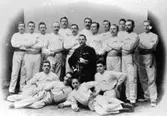 Falköpings 1:a Gymnastik-klubb 1895, ledare fanj. m.m. J.A. Ahlberg. Stående, från vänster: John Swedmark, Fr, Bohman, Gustav Andersson, en                                                     provisor, Sigurd Johanson, David Bohman, J.V. Ander, David Holmblad, Aron Holmblad, Elias Westlin, Torsten Haglund, Hjalmar Lundin och Knut Nilsson. Liggande från vänster:  Primus Forss, Arvid Jakobson, John Tengbom och Karl Warenberg (Ahlbergs). Gåva av fru Sigrid Lundin.