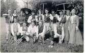 Kulturhistoriska festtåget och festspelen i Falköping den 5 augusti 1934. Skördefolk. Utrustade med brukliga handredskap drar en flock drängar och pigor ut till arbete på åker och äng. De medför matväskor (