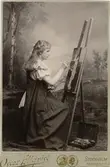 Ett porträtt av Ester Ellqvist-Bauer när hon som 17-åring sitter vid sitt staffli och målar. Bilden blev prisbelönt vid Stockholmsutställningen 1897.