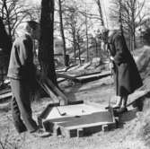 En kvinna och en man spelar minigolf i Huskvarna stadspark.