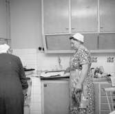 Interiör av köket, två kvinnor.
Axel Andersson (beställare)