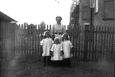 En kvinna och tre flickor.Hedvig, Brita och Ingeborg Johansson med modern Emilia Johansson.Bilden kan vara tagen på gården till Nobelgatan 8 i Örebro (jämför med bild 10, 11, 19).