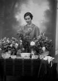 Agnes Johnson vid ett bord med blommor och kristallskålar. Födelsedag? Johnsons privata bilder.