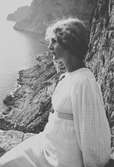 Porträtt av Ester Ellqvist-Bauer vid en klippa i Italien, troligen Capri.