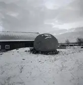 En gravmarkering i form av en stor rund sten mitt på en stensättning som är över 40 meter i diameter.