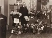 Pastor Oscar L. Carlsson (1875-1955), 
Balltorps missionsförsamling, står omgiven av blomsterbuketter vid uppvaktningen på sin 75-årsdag, 1950-09-22.