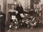 Pastor Oscar L. Carlsson (1875-1955), 
Balltorps missionsförsamling, står omgiven av blomsterbuketter vid uppvaktningen på sin 75-årsdag, 1950-09-22.