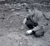 K-G Petersson utför en arkeologisk undersökning vid Klinta 1957. Här har man funnit ett svärd.