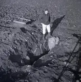 Amanuens Ulf Erik Hagberg framför en hällkista.