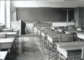 En typisk skolsal från 1940-1950-talen. Möjligen kan den här bilden vara tagen i samband med Lindöskolans invigning 1945 då det inte finns någon annan skola i Kalmar som  stämmer tidsmässigt och inredningen här ser ny ut.