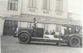 Kalmar brandkårs första stora stegbil utanför brandstationen omkring 1934-35. T.v. brandchefen Florin och längst till höger bilbesiktningsman Folke B Sundberg.