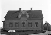 Villabygnad, tre damer poserar sittande på gräsmattan ca:1919
	Metallutfällning, repor, prickhål i emulsionen.