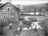 Översvämning, kvinnor utanför hus tillhörande Brunzells Pensionat, Rättvik, Dalarna 1909