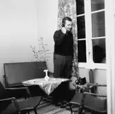 En man står och pratar i telefon i SSU:s sommarhem på Vista kulle utanför Huskvarna.