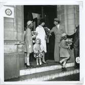 Prinsparet lämnar Stadshotellet efter lunchen. På trappan syns prinsessorna Margareta, Christina och Desirée, deras mor prinsessan Sibylla och prins Gustaf Adolf.