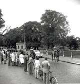 Folket väntar längs kortegevägen på kungligt besök under hantverksmässan 1947.