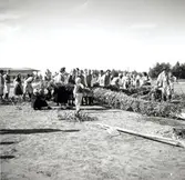 Deltagare under hantverksmässan i Kalmar 1947 reser midsommarstången.
