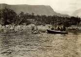 Män anländer med två båtar till Akkajaures strand vid Vaisaluokta.