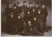 Från 1871 kunde även kvinnor avlägga studentexamen, fram till 1928 dock endast som privatister. Ofta läste den in kurserna på flickläroverk.
På denna bild syns sju kvinnor, troligen kvinnliga tentander, fem gymnasister, en man i plommonstop och en pojke från realskolan med dess mössa.
