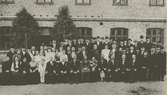 Gruppbild utanför Stora sliperiet år 1909 med de nio medaljörerna, bolagsstyrelsen med flera.