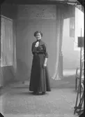 Porträtt av kvinna, Wilhelmina Karlsson, stående i helfigur. Ateljéfoto.