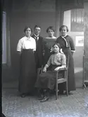 Gruppbild, fyra (4) kvinnor och en man i helfigur varav en kvinna sitter. Ateljébild. Beställare: Hilma Flingström. Thåstorp.