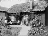 Interiör från Guldskärskvarteret 25. Rebecka Andersson, Josef, Sara och Tyra Edhlund. Stående på trappan Ruth Skötsner, Östhammar, Uppland 1906