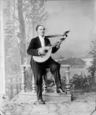 Ateljéporträtt - Oscar Nilsson-Halloff spelar på sin luta, Östhammar, Uppland