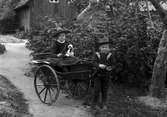 Lekande barn med tvåhjulig vagn.
Karl Bergström