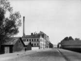 Två och tre vånings bostadshus.
 Örebro Bryggeri tomten till höger.
 Fabriksgatan söderut från Vasagatan.
Bilden är troligen en reproduktion (1934) efter en bild tagen ca 1903 av fotograf Bernhard Hakelier.