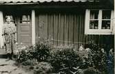 Rosina ... framför sin stuga omkring 1956.