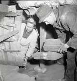 En man arbetar med installation av värme i Räpplinge kyrka 4/2 -1958.