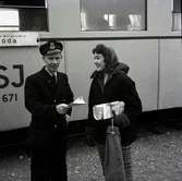 En tjänsteman och en kvinna framför en rälsbuss vid Ölands järnväg.