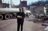 En man fotograferad framför en tankbil vid Forsebron i Mölndal, 1960-tal. I bakgrunden till vänster ses byggnader tillhörande SOAB. I mitten ses Stora Götafors och till höger Götaforsliden 1-5.

För mer information om bilden se under tilläggsinformation.