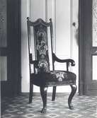 Stolen inköpt på en auktion i Kristdala i början av 1930-talet. Stolen är tillverkad i slutet av 1700 - början av 1800-talet. En mycket sittriktig och stabil stol fogad med tappar och dymlingar. Har drag av rokoko, men torde vara ett bondesnickeri. Förg: svart med gulddekoration. Rygg-och sittklädsel broderad. Stolen var 1982 placerad i sommarstugan Paradiset, Mörtfors badanstalt.