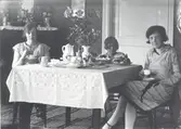 Kring kaffebordet. Från vänster: Ebba Johansson gift med lantbrukaren John Johansson, Riskebo, dottern Greta och längst till höger Ebbas syster Gerda, gift Fransson.