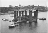 Oljeplattform byggd på Finnboda varv bogseras på Stockholms ström 1972. Bland bogserbåtarna återfinns BILL och STARKGROGG; i bakgrunden t v ses även FINNBODA III (urspr. WIDAR).
