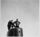 Lennart Wållberg Norrköping var förste kock på ubåten Neptun 1954 Neptuns långresa 1954.
Fartygschefen, Bertil Erkhammar övervakar torpedbärgning från tornet.