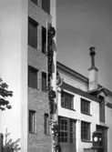 Brandmän på stegar vid brandstationens slangtorn. Bilden från 1930-talet.