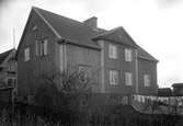 Bostadsfastighet med adress Smedjegatan 5 på en bild tagen i början på 1930-talet. Till vänster syns en gavel på Frans Elinders villa.