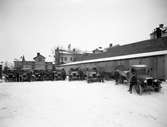 Lastbilar med chaufförer anställda i Erland Nyréns åkeri uppställda på den plats där ett hyreshus med adressen Åttkantslunden nu reser sig. Bilden tagen i slutet av 1920-talet.