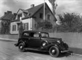 Bil från Geijers Motoraffär, en Chevrolet Master De Luxe 1934, parkerad på Museigatan samma år.