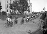En amerikansk idrottstrupp cykelparaderar på väg till Tingvalla i slutet av 1930-talet.