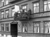 Del av exteriören för en hyresfastighet med adress Rosenbadsgatan 1. Fastigheten byggdes 1905 av bokhållare Oskar Thorén och såldes vidare 1922 till byggmästare Gottfrid Johansson. Huset, ett av Karlstads största trähus någonsin, revs år 1968.