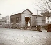 Karl Nyströms andra ateljé innan flytten till Klara 1902 låg på Östra Kanalgatan i hörnet med dåvarande Åttkantsgatan. Första ateljén, se bild 32.665, revs när Mariedalsgatan las ut år 1900. I dörröppningen står medhjälperskan Olga Nordlöf.